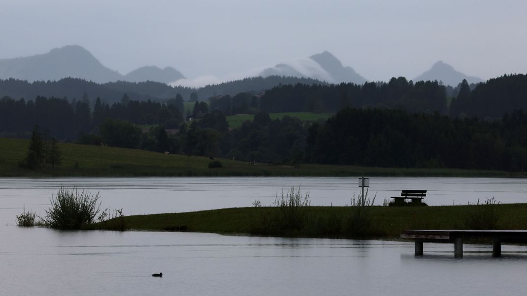 Im Regen liegt der am Alpenrand gelegene Illasbergsee am frühen Morgen.