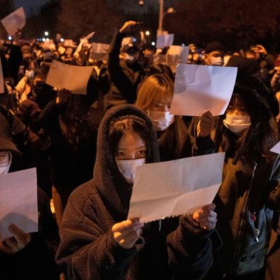 Demonstranten in Peking halten leere Papiere hoch, während sie protestieren.