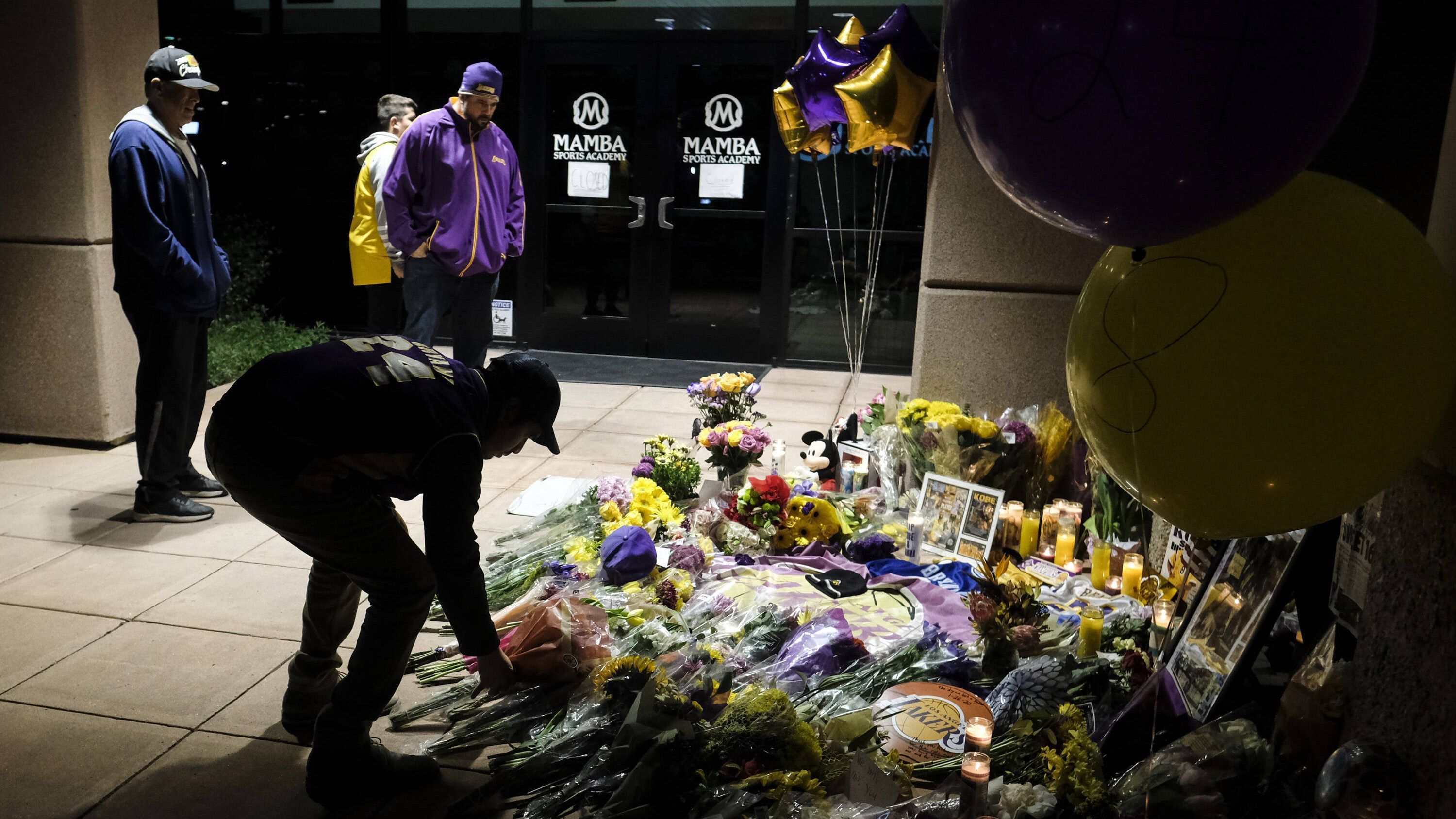 
                <strong>Kobe-Fans vor der Mamba Academy </strong><br>
                Angeblich soll Bryant mit seiner Tochter Gianna am Sonntag unterwegs gewesen sein, um sich ein Basketball-Spiel an seiner Mamba Sports Academy anzugucken. Seine Tochter hätte wohl auch dort spielen sollen. Neben den hunderten Kindern, die sich dort auf ihren großen Basketball-Helden gefreut hatten, pilgerten auch zahlreiche Fans an die Stätte, um Abschied zu nehmen. 
              