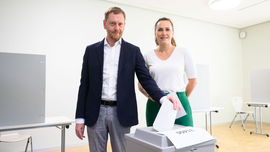 Michael Kretschmer (CDU), Ministerpräsident von Sachsen, steht mit seiner Frau Annett Hofmann bei der Stimmabgabe zur Landtagswahl in Sachsen im Wahllokal an einer Wahlurne. 