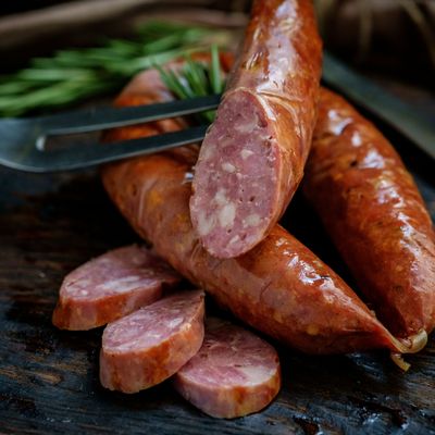 Bavarian smoked sausages from pork cut on a wooden Board. Rustic style