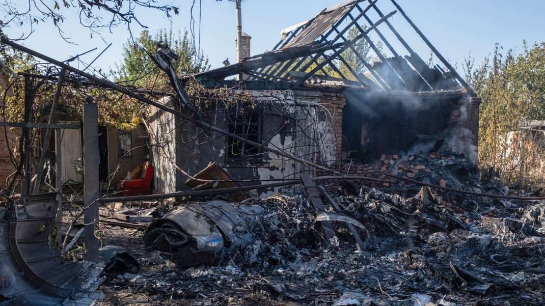 Archivbild, 5. Oktober 2024, Ukraine, Kostjantyniwka: Ein beschädigtes Haus ist im Hintergrund von Fragmenten eines abgeschossenen russischen Militärflugzeugs am Stadtrand von Kostjantyniwka, einer Stadt nahe der Frontlinie in der Region Donezk, zu sehen. 