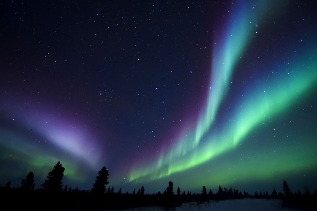 Diese Polarlichter in Kanada leuchten grün und violett.