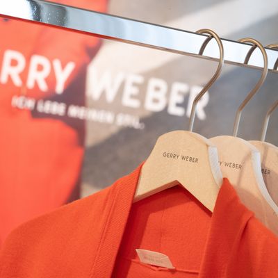 Kleidung des deutschen Modeunternehmens Gerry Weber hängt auf Bügeln an einem Kleiderständer.
