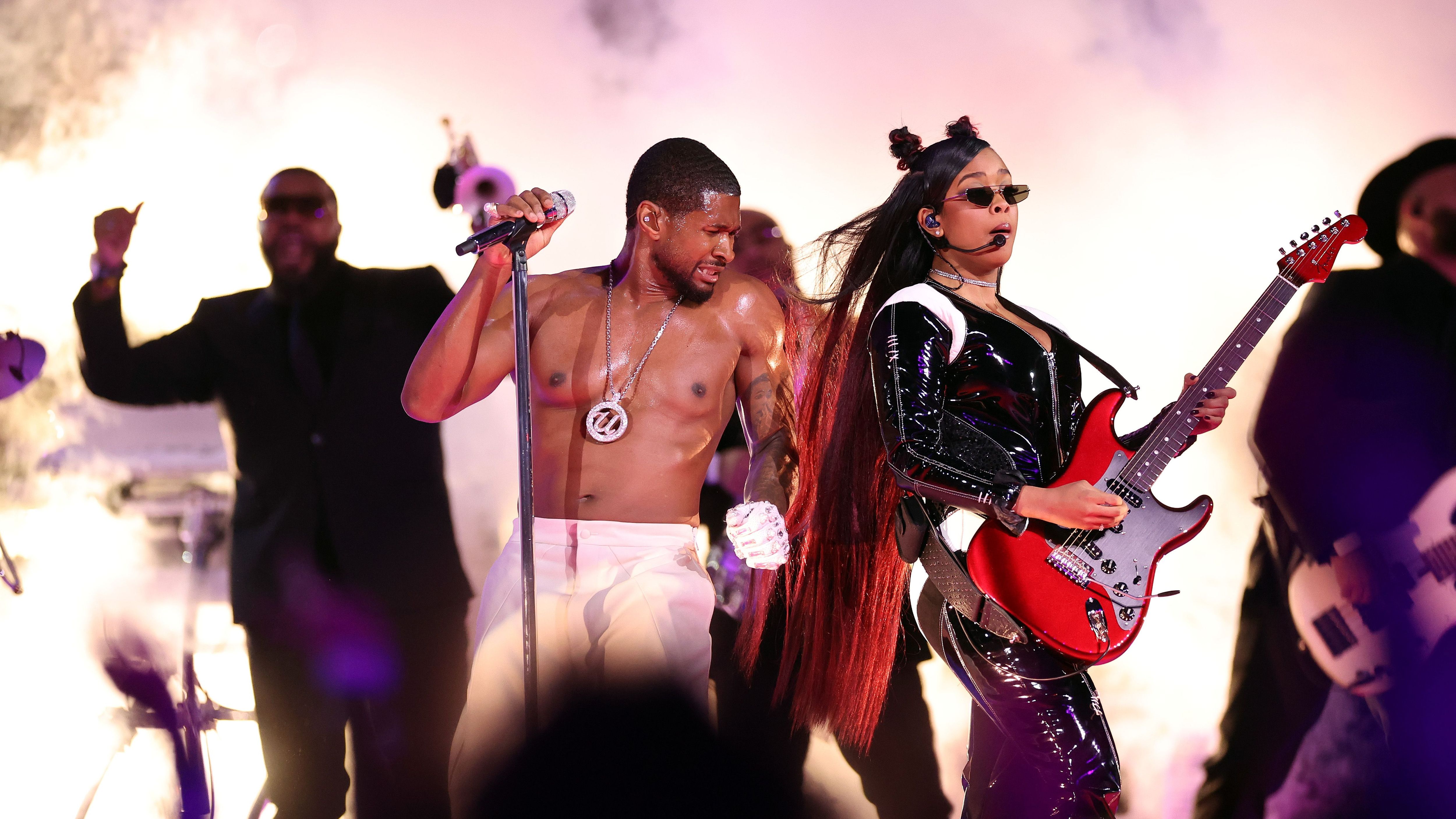 <strong>Usher zieht blank</strong><br>Während der 45-Jährige sich sein Shirt vom Leib reißt, spielt H.E.R. auf ihrer Gitarre.