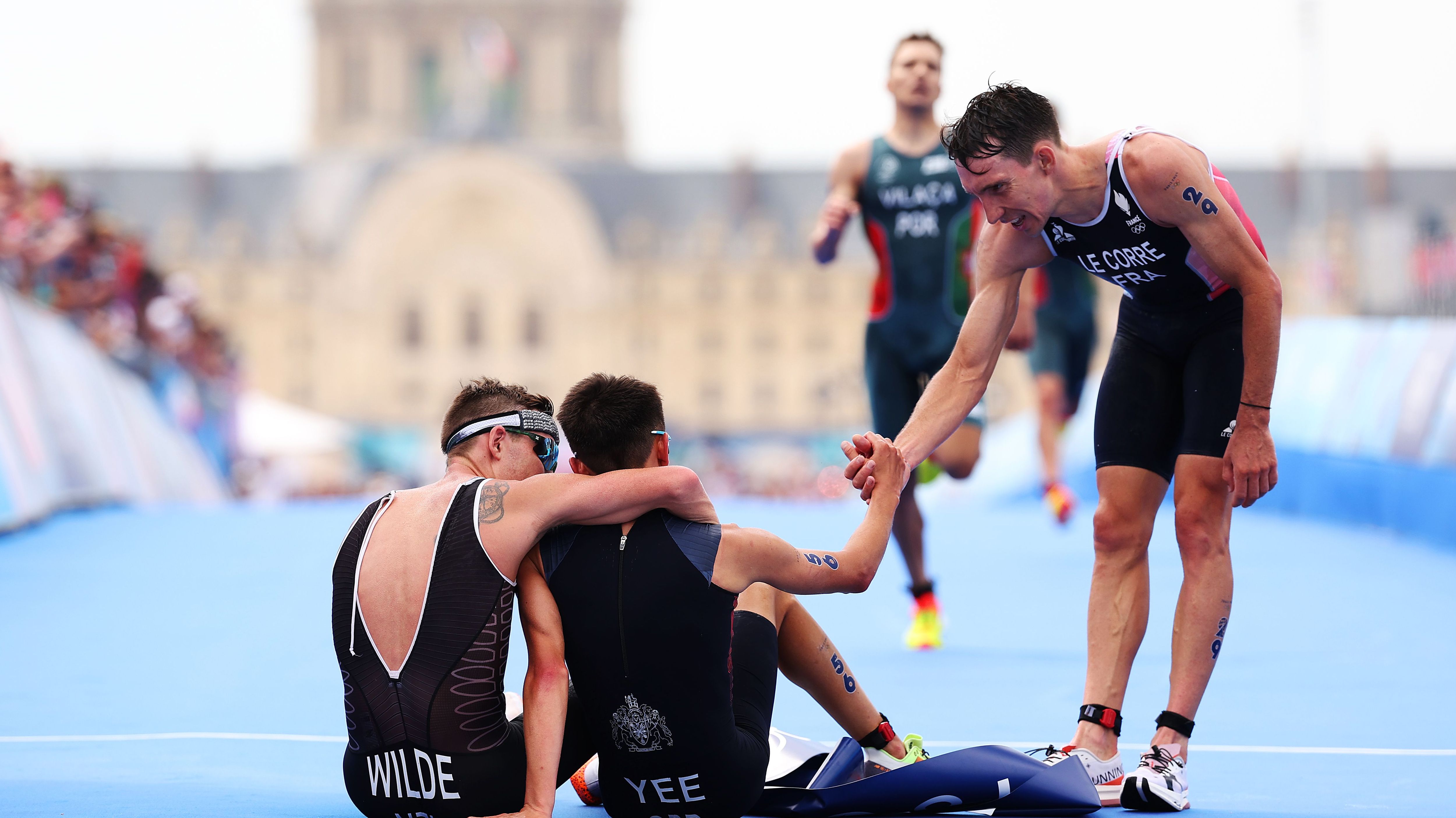 <strong>Olympia 2024: Die besten Bilder des fünften Tages</strong><br>Wow, genau solche Bilder sind olympisch! Gold-Sieger Alex Yee und Silber-Sieger Hayden Wilde liegen nach dem Triathlon kaputt im Ziel. Gemeinsam. Und werden von Pierre de la Corre beglückwünscht.