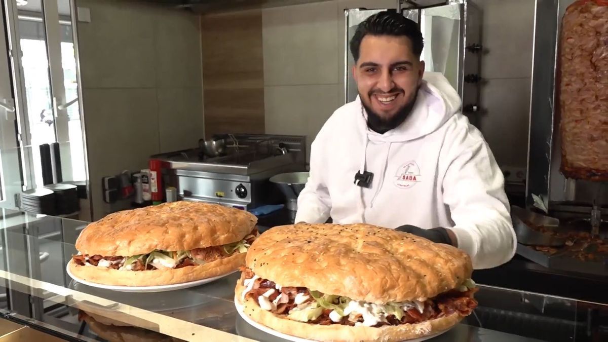 In einem Augsburger Dönerladen zeigt Inhaber Haci Öztürk zwei jeweils etwa zwei Kilogramm schwere Riesendöner.