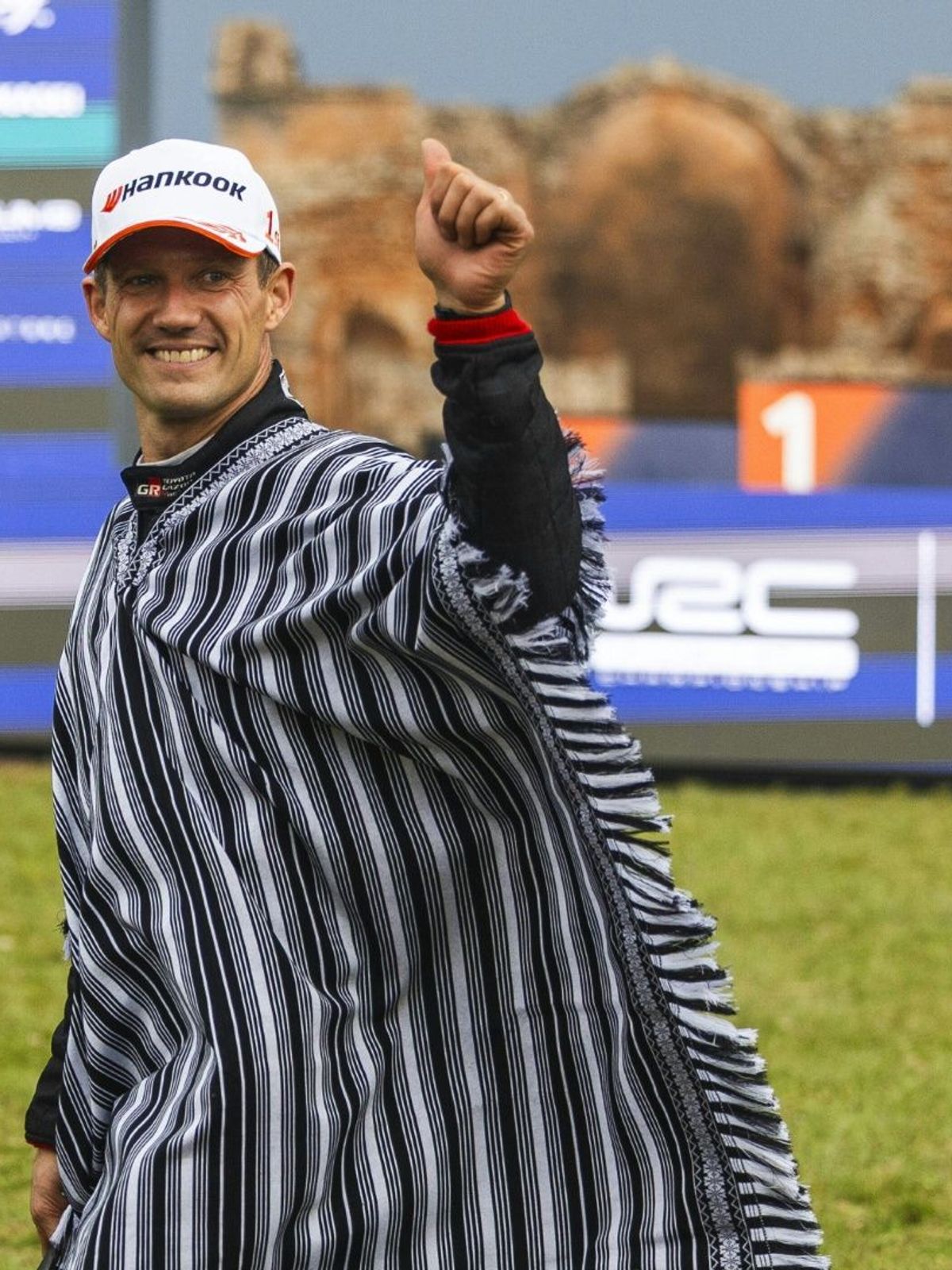 Ogier mit einem Poncho bei der Siegerehrung