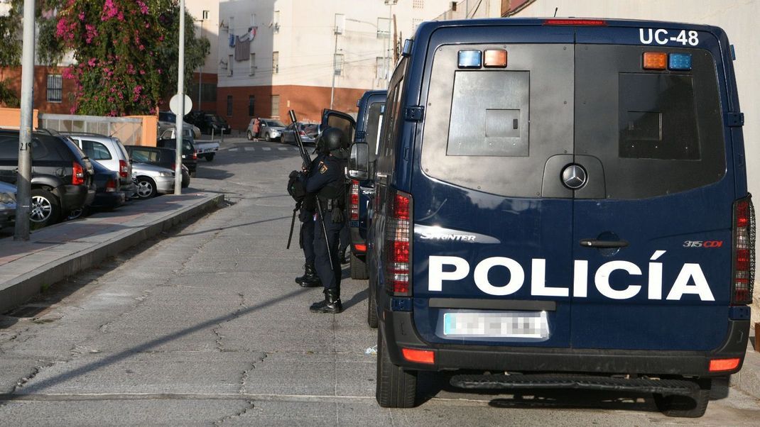 Spanische Polizisten stehen bei einem Einsatzfahrzeug.&nbsp;