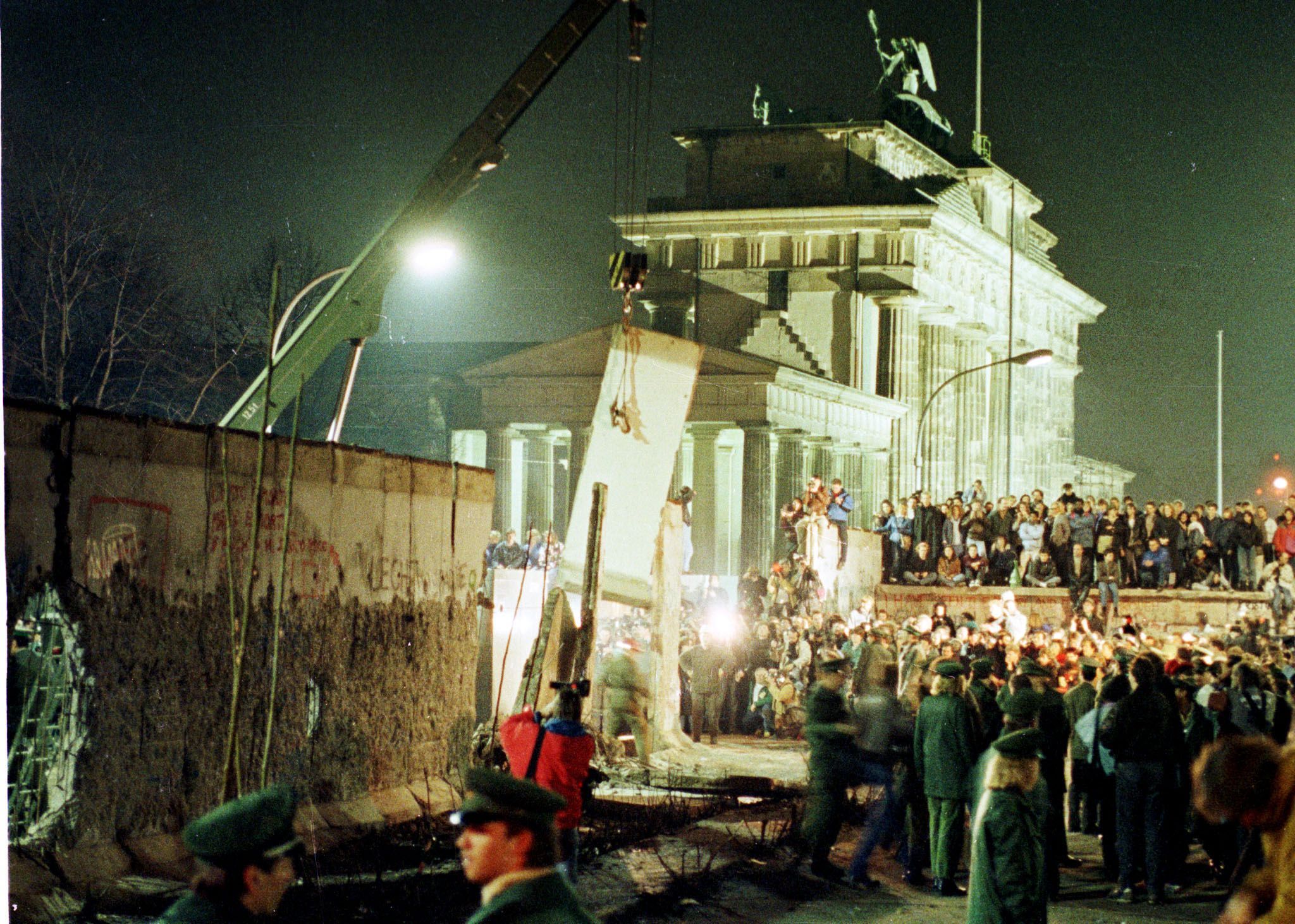 Ein großes Stück der Berliner Mauer wird von einem Kran angehoben, als die DDR mit dem Abbau der Mauer in der Nähe des Brandenburger Tors in Ost-Berlin beginnt, 20. Februar 1990.