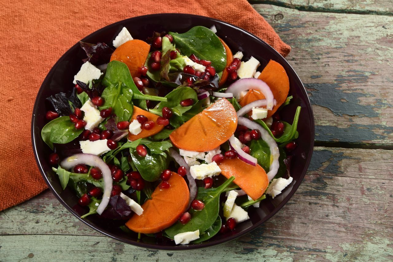 Kaki-Salat | Zutaten (für 2 Personen): 1 Kaki, 1 Granatapfel, 2 Handvoll Baby-Spinat, 100 g Ziegenkäse, ½ Zwiebel, Öl, Essig, Salz, Pfeffer | Zubereitung: Kaki schälen und in dünne Scheiben schneiden. Kerne aus Granatapfel herauslösen. Spinat waschen und trocken tupfen. Ziegenkäse in kleine Stücke zerteilen. Zwiebel in Streifen schneiden. Alle Zutaten in eine Schüssel geben und mischen. Mit Öl, Essig, Salz und Pfeffer abschme