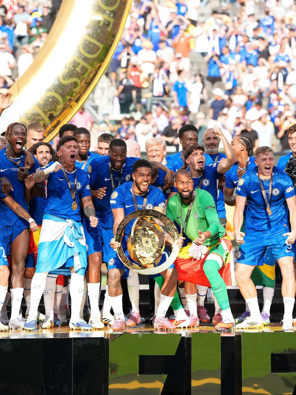 Reece James (Chelsea FC, 24) haelt den FIFA Club World Cup 2025 Pokal, waehrend Chelsea nach dem Sieg gegen Paris Saint-Germain im Finale feiert. US-Praesident Donald Trump ist auf der Buehne, um m...
