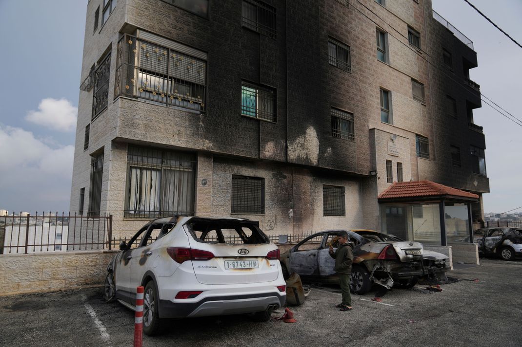 Ein palästinensischer Junge schaut am Rande der Stadt al-Bireh im Westjordanland palästinensische Fahrzeuge an, die bei einem frühmorgendlichen Angriff israelischer Siedler verbrannt wurden.