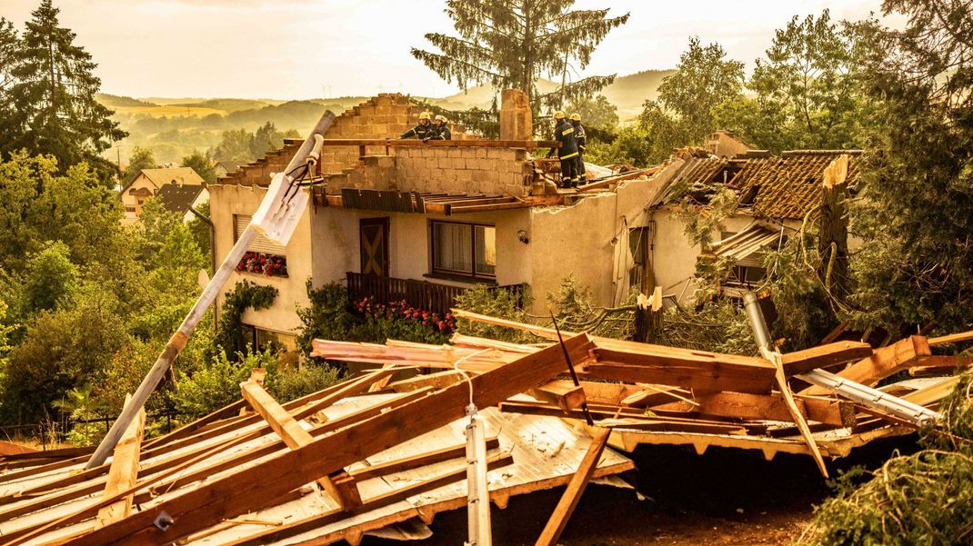 Saarland, Asweiler: Rettungskräfte arbeiten an einem zerstörten Haus, dessen Dach von einem Sturm abgedeckt wurde. 