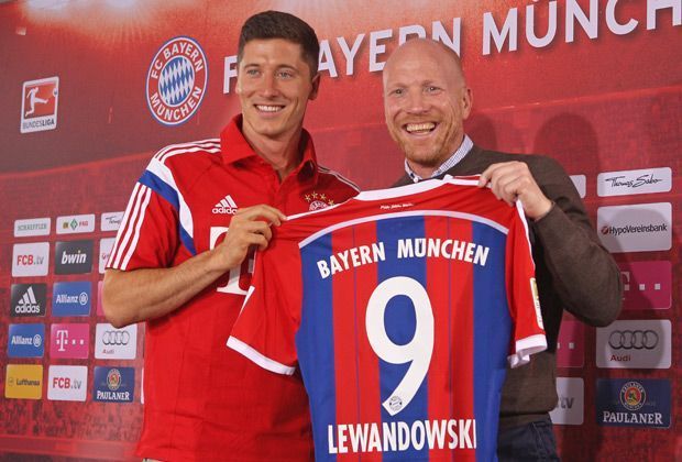 
                <strong>Die neue Nummer 9</strong><br>
                Stolz präsentiert der Pole das neue Heimtrikot der Bayern. Der Stürmer bekommt beim deutschen Rekordmeister die Nummer 9 und tritt damit in die Fußstapfen von Mario Mandzukic.
              