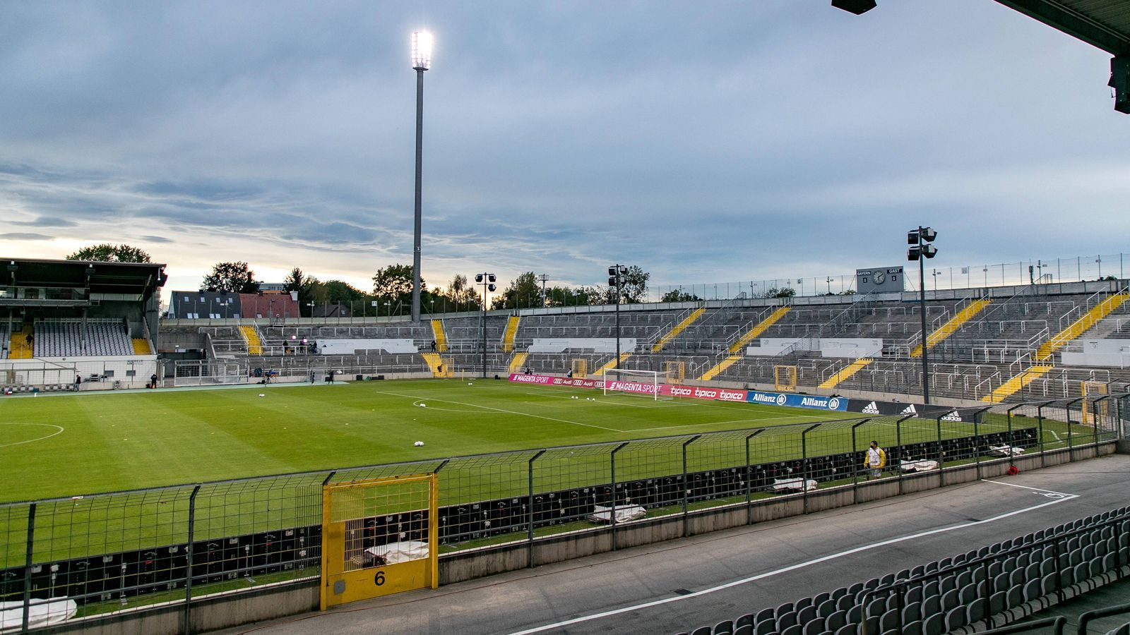 
                <strong>Städtisches Stadion an der Grünwalder Straße (München)</strong><br>
                Wir bleiben in München und gehen weiter zum Städtischen Stadion an der Grünwalder Straße, kurz Grünwalder Stadion. Die Arena war einst schon die Heimstätte von 1860 München, bevor sich der derzeitige Drittligist später mit dem FC Bayern Olympiastadion und Allianz Arena teilten und ist es derzeit auch wieder. Nachdem 1860 München zwischenzeitlich bis in die Regionalliga Bayern abrutschte, kehrte der Traditionsklub aus Giesing ins Grünwalder Stadion zurück spielt dort bis heute. Zudem ist das 1911 erbaute Stadion derzeit auch noch die Heimstätte der zweiten Mannschaft von Bayern München, die ebenfalls in der 3. Liga kickt und in der Vorsaison als Aufsteiger sogar Meister wurde.
              