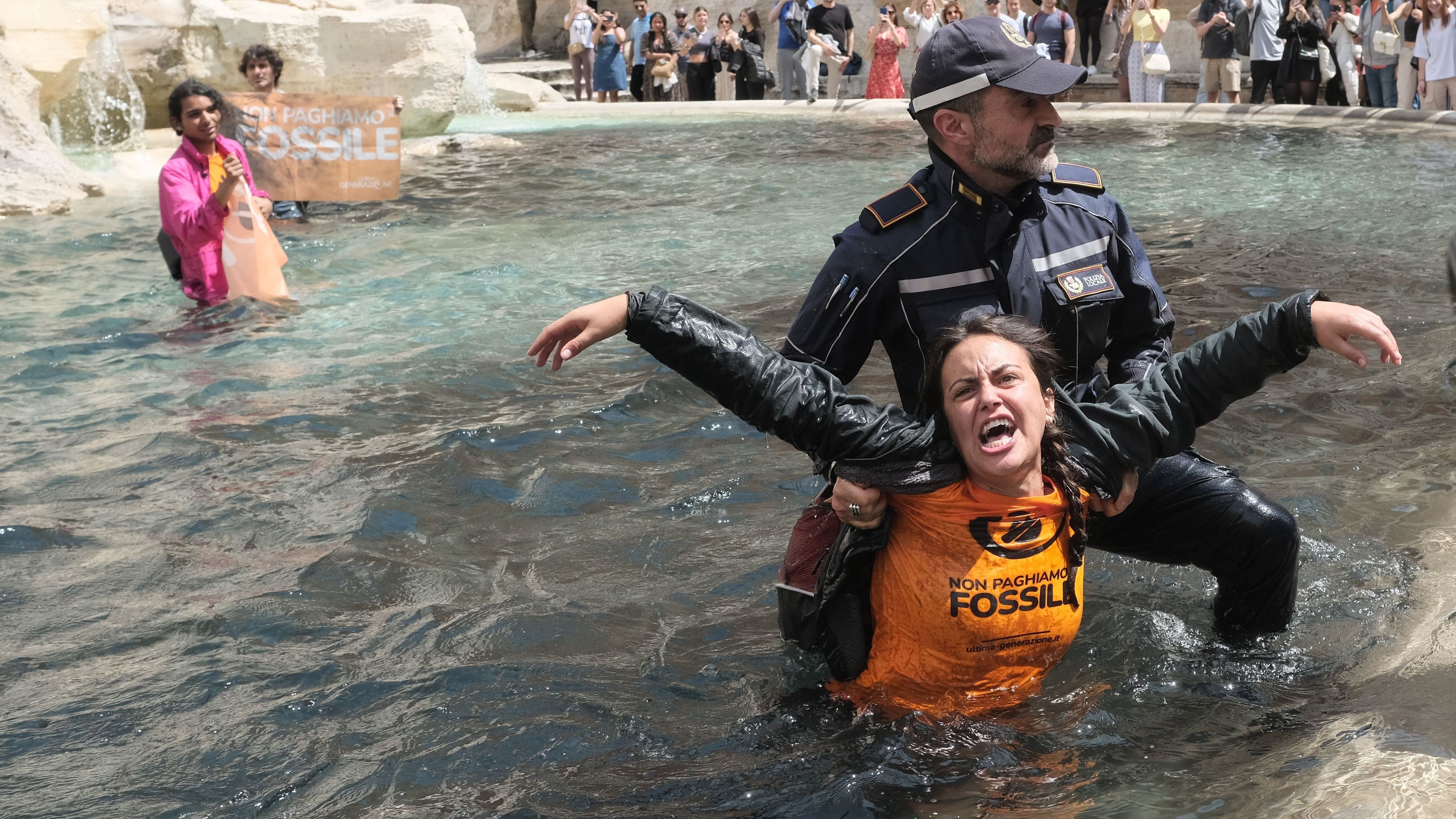 Klimaaktivist:innen der "Letzten Generation" werden aus dem Trevi-Brunnen abgeführt.