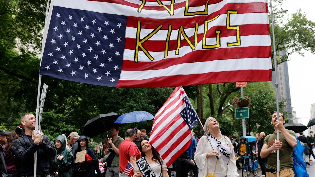 "No Kings" - "Keine Könige" haben diese Demonstrant:innen auf die US-Flagge geschrieben.