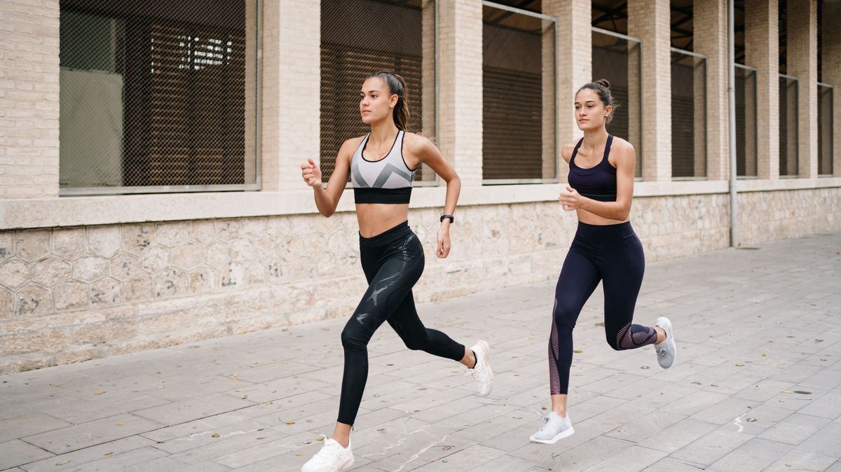 Zwei junge Frauen joggen durch Innenstadt