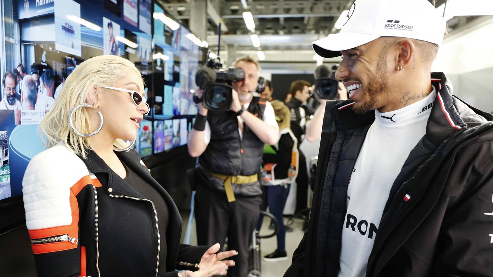 
                <strong>Hamilton Superstar: Musik-Debüt mit Christina Aguilera </strong><br>
                Lewis Hamilton ist der Superstar der Formel 1. Kontrovers, bunt, schillernd. Keine Frage: Der sechsmalige Weltmeister hat viele Talente. Musik zum Beispiel. Wie er jetzt offiziell verriet, gehört die mysteriöse Männerstimme in Christina Aguileras Song "Pipe" ihm. "Ich bin XNDA", bestätigte Hamilton. Er ist der Musiker ist, der bei der Veröffentlichung des Songs 2018 die Stimme beisteuerte.
              