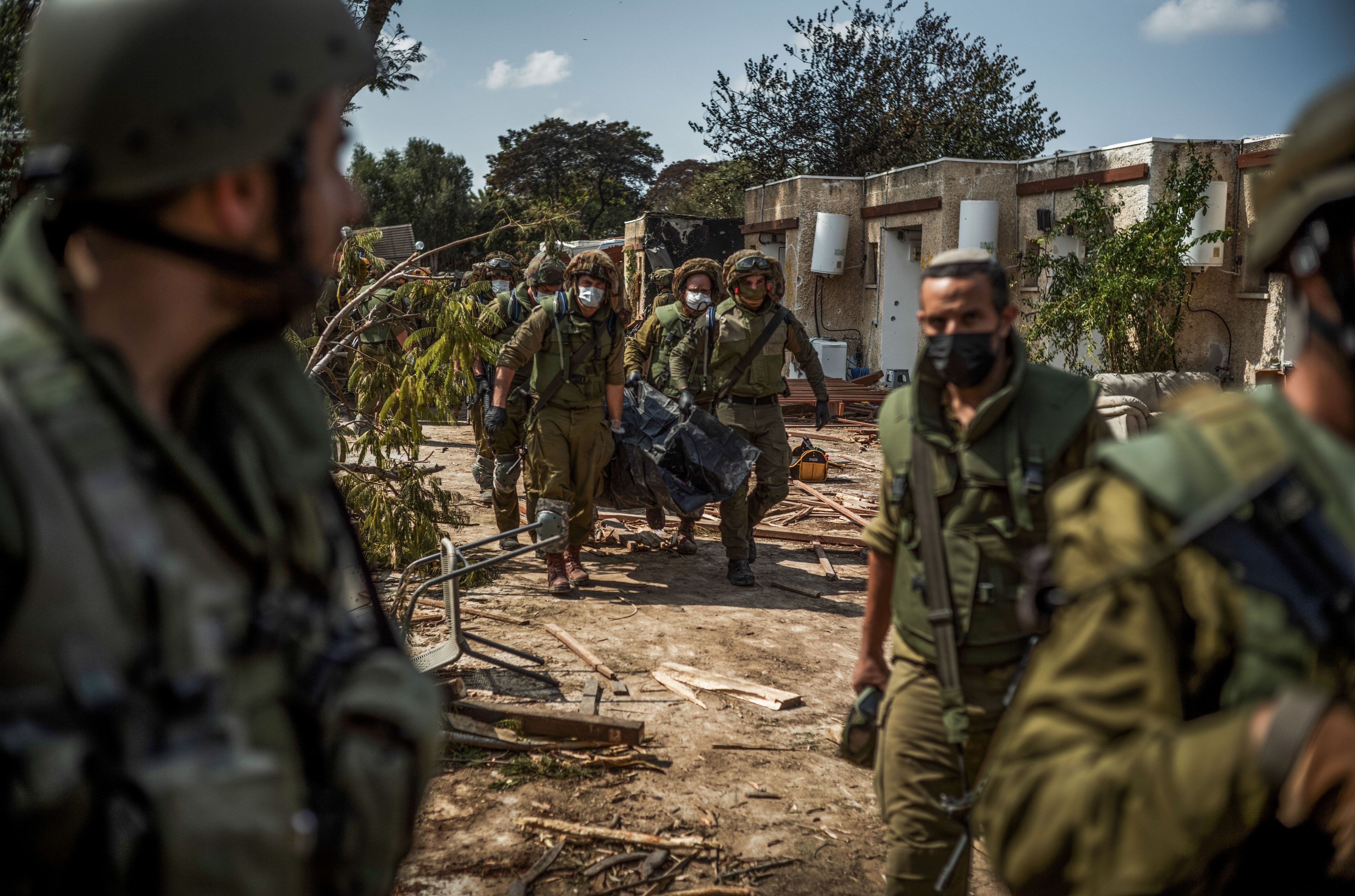 Israelische Soldat:innen bergen die Leichen ermordeter Bewohner:innen im Kibbuz Kfar Aza.