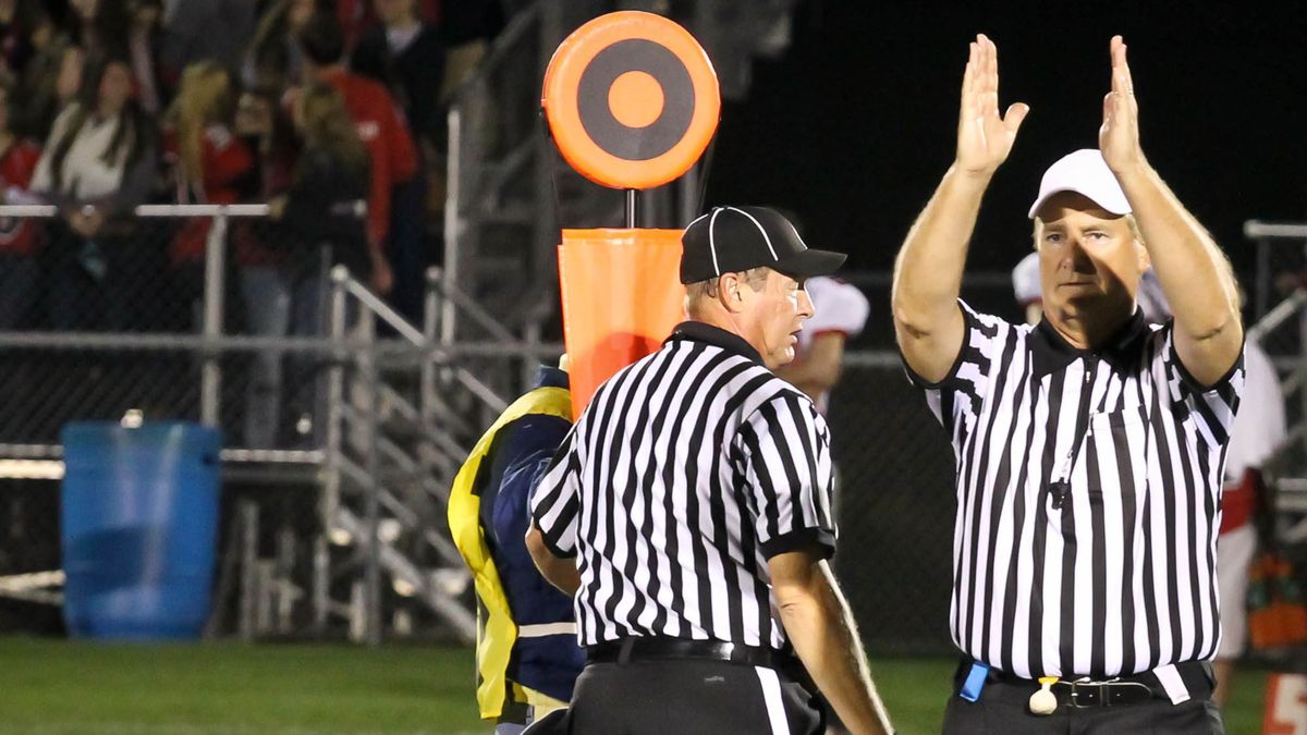 Football Referees Gesturing Fourth Down and Short, Referees with chain gang measuring yardage, indicating that its fourth down and short.