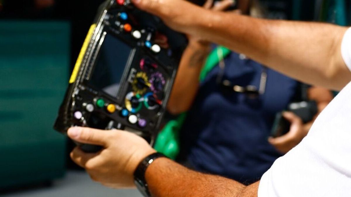 Symbolbild: Formel-1-Fan mit Lenkrad im Fahrerlager
