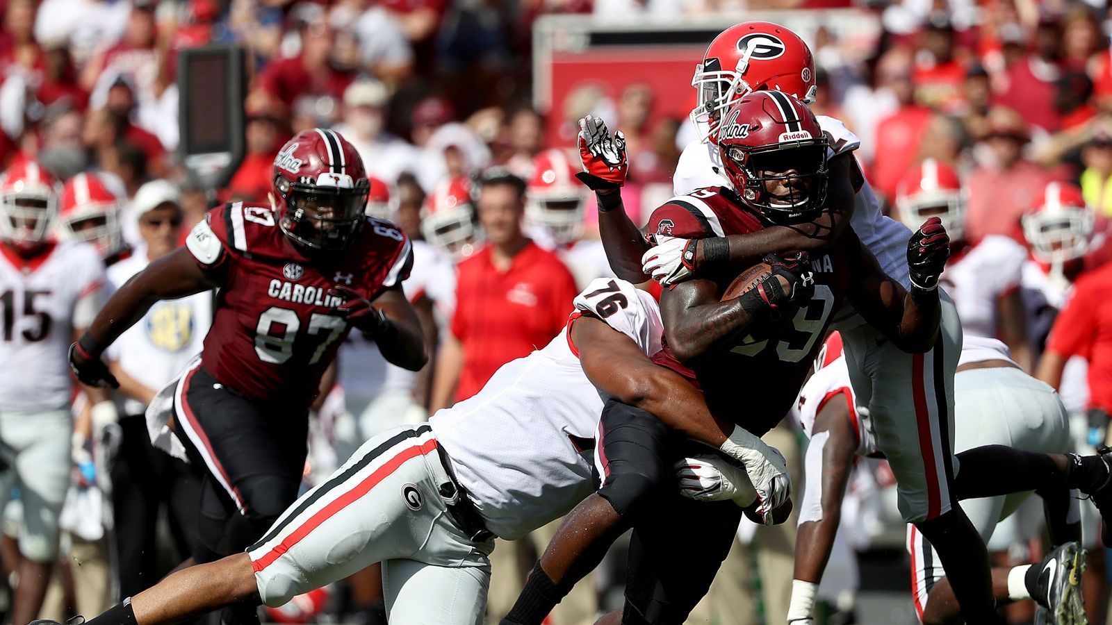 
                <strong>Rivalität</strong><br>
                Wenn die South Carolina Gamecocks und die Georgia Bulldogs aufeinandertreffen, lebt eine der ältesten Rivalitäten im College-Football auf. Gamecocks und Bulldogs duellieren sich bereits seit 1894, allerdings findet das Spiel erst seit dem Beitritt der South Carolina University in die SEC im Jahr 1992 jährlich statt. Beim sogenannten "Border Bash" am Freitag vor dem Spiel treffen sich in Augusta, Georgia, also genau an der Grenze zu South Carolina, teils Zehntausende von Fans, um gemeinsam zu feiern und mit der Hilfe von vielen lokalen Unternehmen und Sponsoren Geld für wohltätige Zwecke für Kinder in der "Border Bash Foundation" zu sammeln. Während beide Schulmaskottchen sowie die Cheerleaderteams beider Schulen anwesend sind, bleiben Coaches und Spieler der Veranstaltung wegen terminlichen Konflikten in der Spielvorbereitung fern.
              