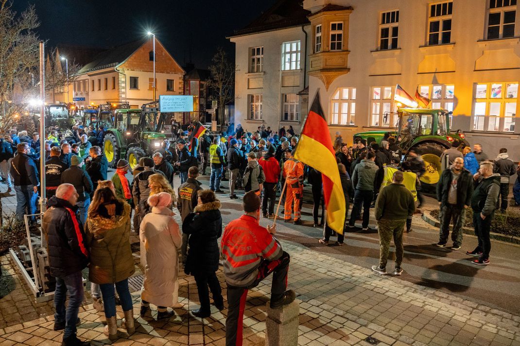  Demonstranten mit Deutschlandfahnen und Traktoren protestieren vor einer Parteiversammlung der Grünen im bayerischen Hirschaid.