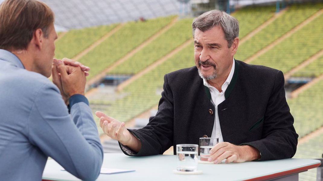Markus Söder (rechts) spricht im ZDF-Sommerinterview für "Berlin direkt" im Münchner Olympiastadion.