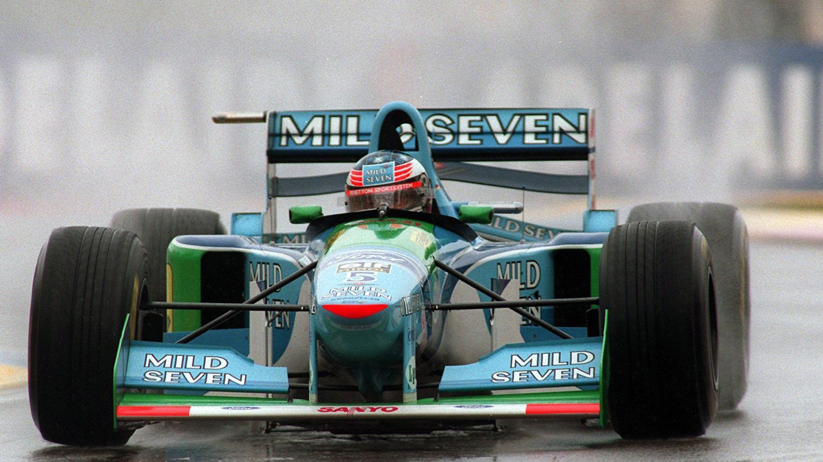 
                <strong>Benetton (1994) </strong><br>
                Anfang der 1990er Jahre sorgten elektronische Entwicklungen für ein neues Fahrgefühl. Die Wagen wurden mit aktiven Fahrwerken, Traktionskontrollen und einem Anti-Blockier-System (ABS) ausgestattet. Zur Saison 1994 wurden die Fahrhilfen allerdings wieder abgeschafft. Das machte das Fahren für Michael Schumacher (Foto) und Co. wieder um einiges anspruchsvoller und unberechenbarer. Als Reaktion auf die tödlichen Unfälle von Ayrton Senna und Roland Ratzenberger 1994 ordnete die FIA vergrößerte Cockpits an. Auch höhere Seitenwände sollten ab Mitte der 1990er zusätzlich zum Schutz der Fahrer beitragen. 
              