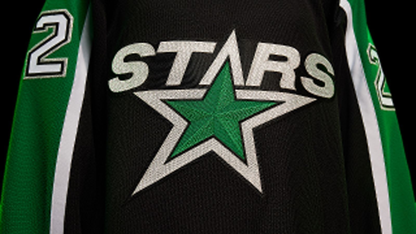 
                <strong>Dallas Stars</strong><br>
                Die Stars modernisieren das Trikot der Eröffnungssaison des Teams mit der aktuellen Farbpalette. Der Schriftzug "STARS" und das Logo verschmelzen zu einer Einheit, während die Schulteraufnäher Bilder des Bundesstaates Texas mit einem "D" enthalten, das den Standort Dallas markiert.
              