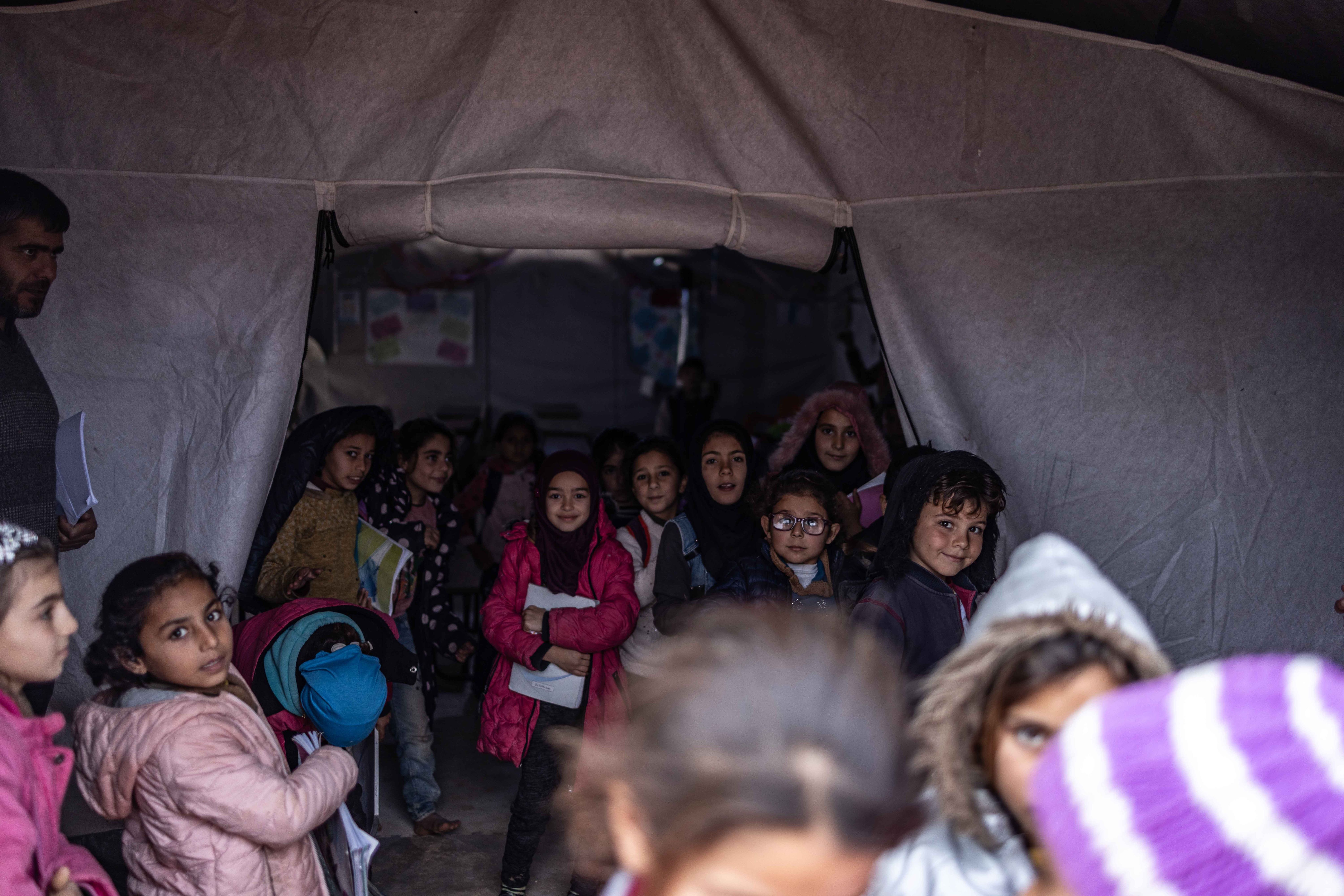 Syrien, Aleppo: Syrische Kinder, die an einer Unterrichtsstunde im Rahmen des Bildungszeltprojekts der humanitären Nichtregierungsorganisation "Orange Organization" in einer Notunterkunft für die vom Erdbeben Betroffenen teilnehmen. 