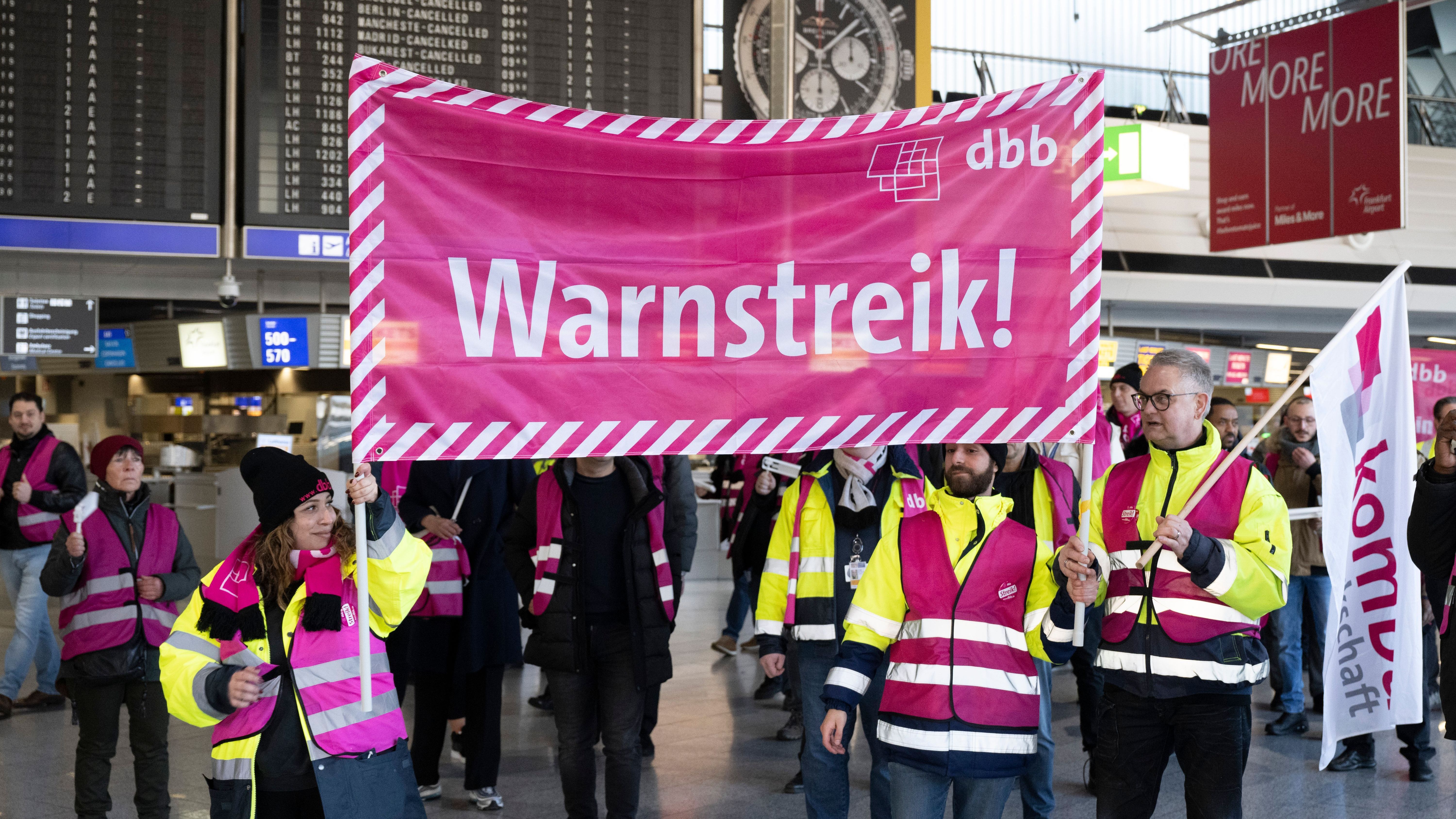 Frankfurt/Main: Streikende laufen mit Bannern durch das Terminal des Flughafens Frankfurt. Mit einem großangelegten bundesweiten Warnstreik haben die Gewerkschaften EVG und Verdi am Montag weite Teile des öffentlichen Verkehrs lahmgelegt. 