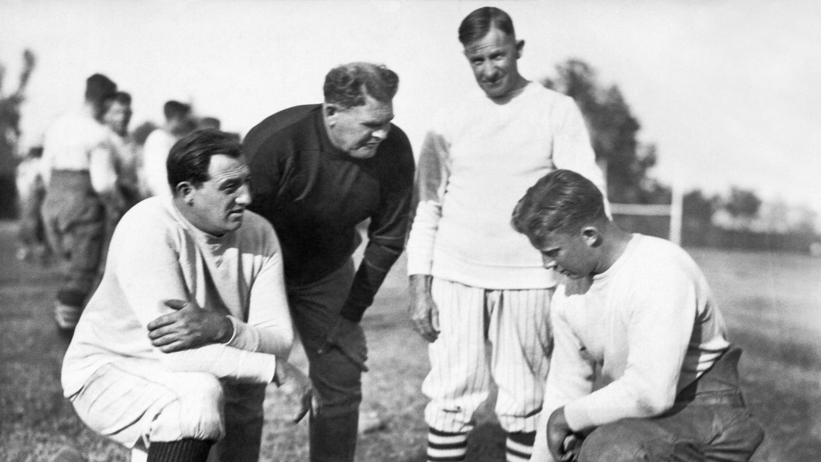 
                <strong>Eine Legende</strong><br>
                Der schon erwähnte Glenn Scobey Warner, besser bekannt als Coach "Pop" Warner (2.v.l.), war einer der Innovatoren des Footballs. Er erfand unter anderem den Drei-Punkt-Stand, die moderne Blocktechnik, und war einer der ersten Coaches, die den Huddle benutzt haben. Die "Pop Warner Football"-Organisation kümmert sich seit jeher um den Fortbestand des Kinder- und Jugendfootball in den USA. Gerade weil es hier keine Sportverbände gibt, die den Amateursport organisieren, ist dies umso wichtiger.
              