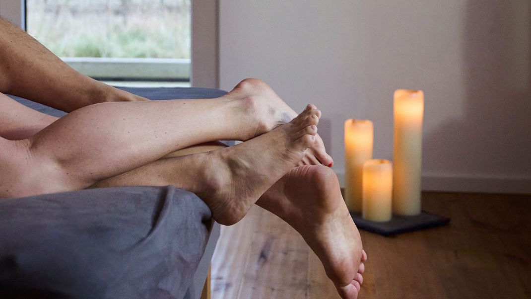 Eine Frau und ein Mann liegen eng umschlungen in einem Bett. Doch das findet laut einer neuen Umfrage tendenziell immer seltener statt. 