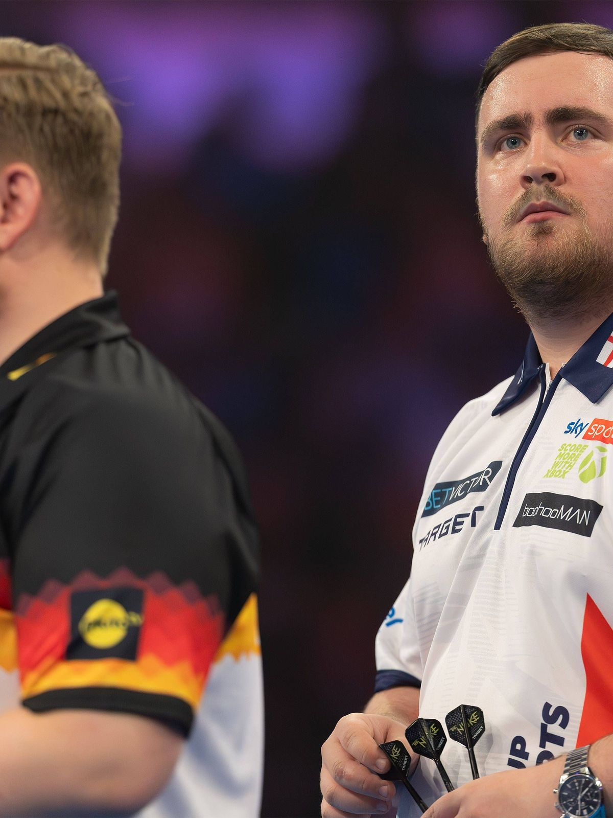 World Cup of Darts 2025 Luke Littler (England), links im Vordergrund Martin Schindler (Deutschland). PDC World Cup-Zweitrundenspiel zwischen England und Deutschland am 14. Juni 2025 in der Eissport...