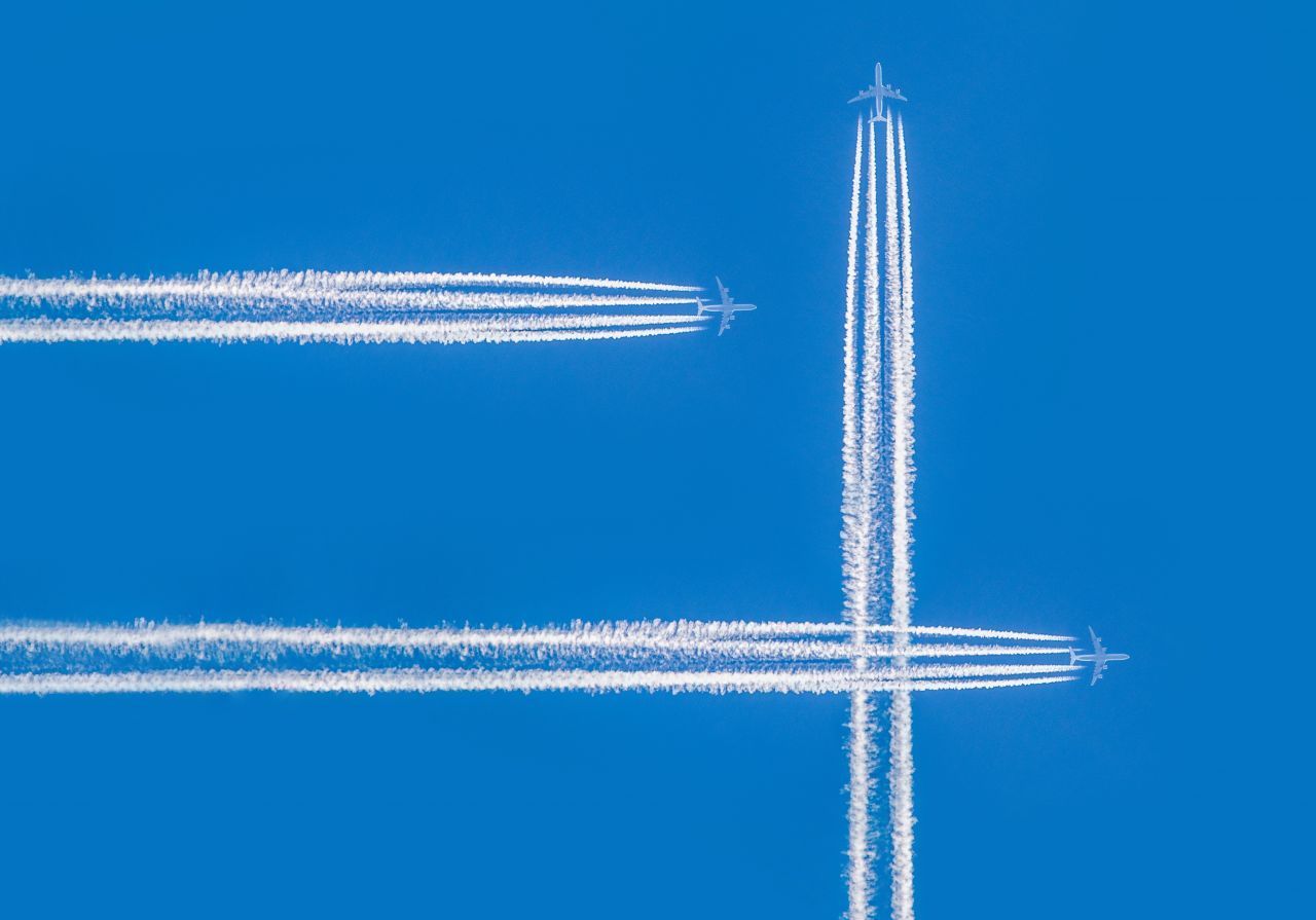 Streifen, die sich kreuzen, können von Flugzeugen stammen, die in unterschiedlichen Höhen fliegen. 