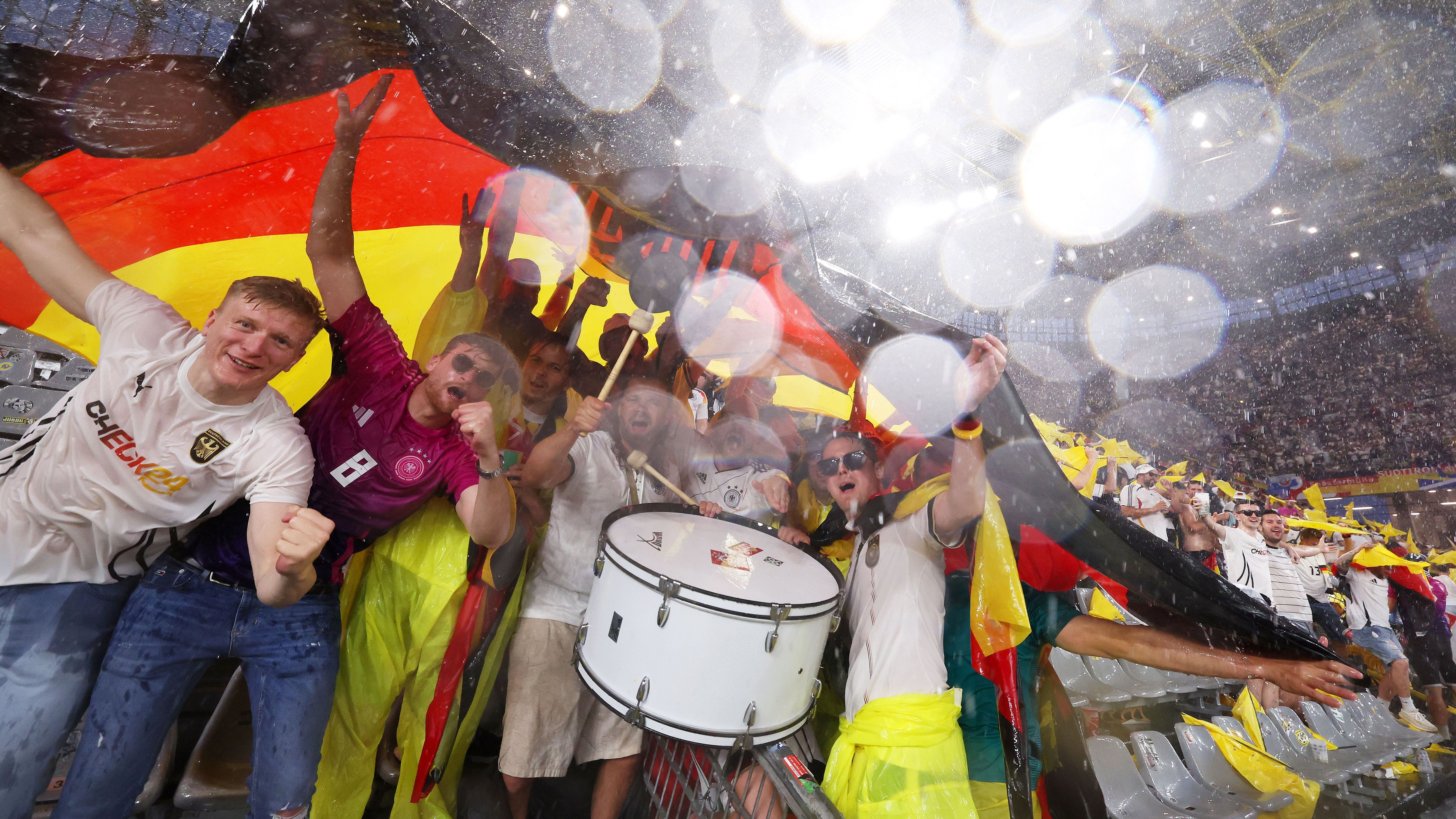 <strong>Partylaune trotz Unwetter und Unterbrechung</strong><br>Auch auf deutscher Seite versuchten die Fans, den widrigen Bedingungen zu trotzen und feierten auf der Tribüne einfach weiter. Nach gut 25 Minuten konnte die Partie zwischen dem DFB-Team und Dänemark in Dortmund fortgesetzt werden.&nbsp;