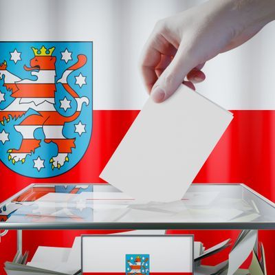 Thuringia flag, hand dropping ballot card into a box - voting/ election in Germany concept - 3D illustration