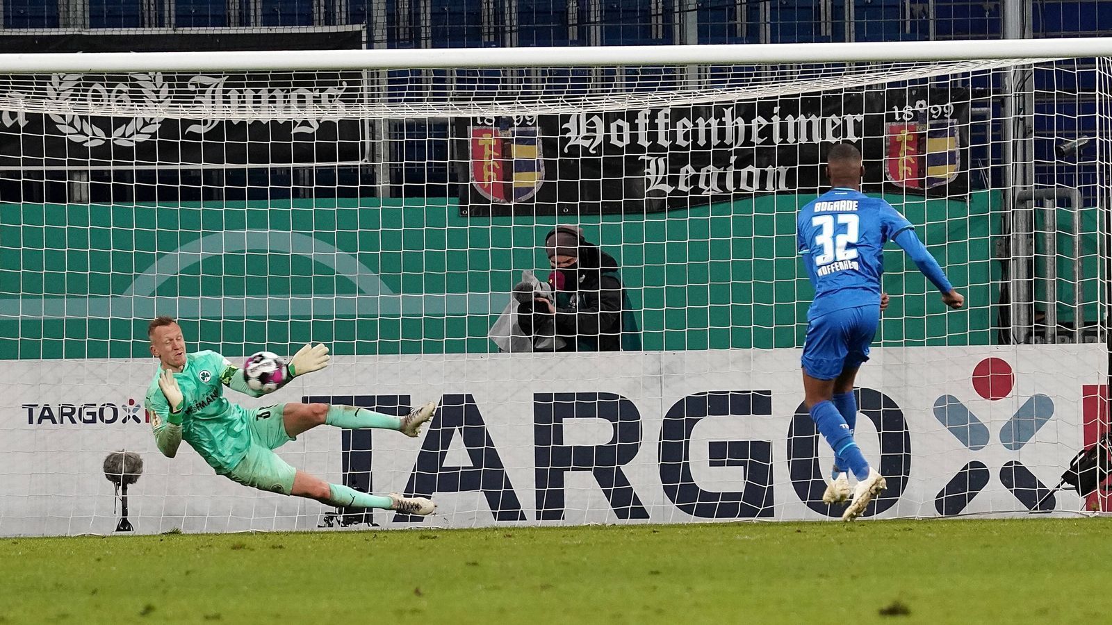 
                <strong>Platz 7 (geteilt): TSG Hoffenheim - Greuther Fürth 8:9 n.E. (18 Elfmeter/ Saison 2020/2021)</strong><br>
                Fast wäre es gar nicht zu diesem Elfmeter-Krimi gekommen. In der Nachspielzeit hatte Paul Seguin den Siegtreffer auf dem Fuß. Doch seinen Elfmeter in der 94. Minute parierte Hoffenheims Torwart Oliver Baumann. Es ging in die Verlängerung und später dann ins Elfmeterschießen. Hier hätte die TSG in Person von Kevin Vogt alles klarmachen können, der Verteidiger knallte den Ball aber über das Tor. Letztendlich traf sein Teamkollege Kasim Adams wenig später nur die Latte, Marco Meyerhöfer schoss Fürth mit dem 18. Elfmeter eine Runde weiter.
              