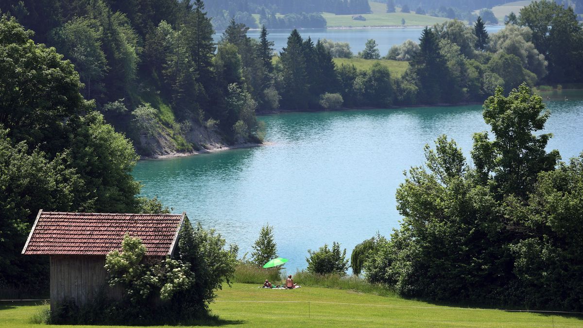 Ausflügler suchen bei hochsommerlichen Temperaturen Abkühlung am Ufer des am Alpenrand gelegenen Forggensees.