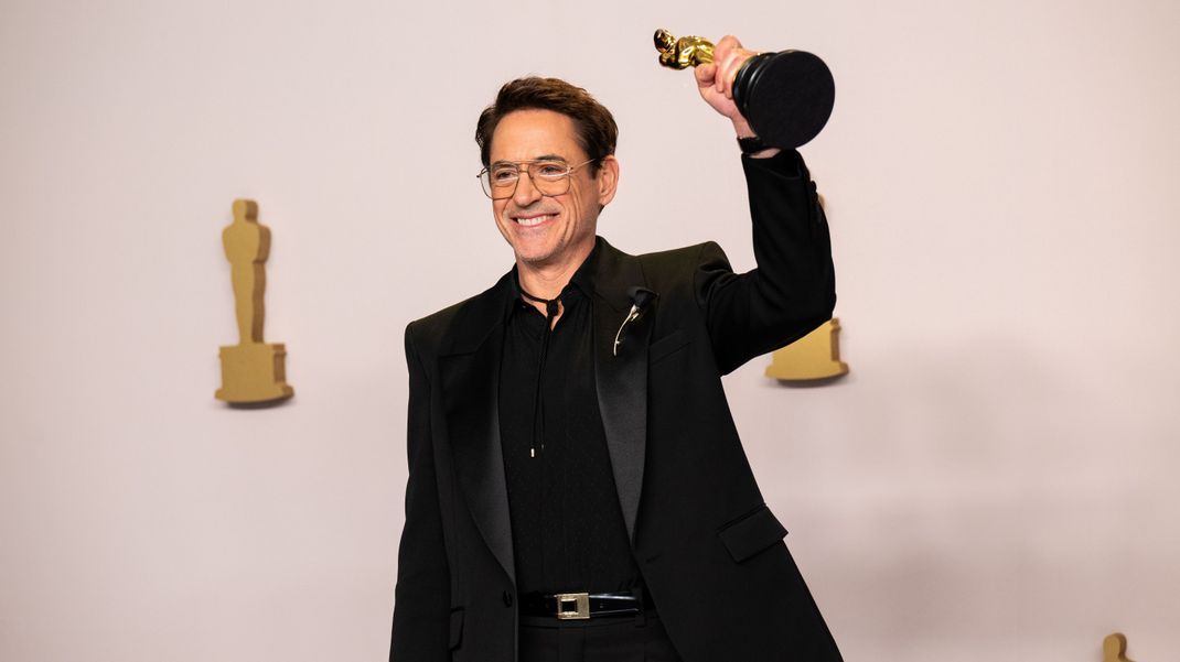 Robert Downey Jr. posiert mit seiner Statue bei den Oscars 2024.