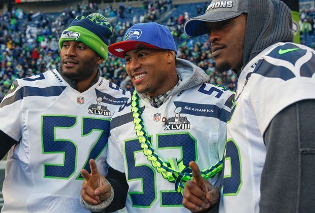 
                <strong>Siegerposen</strong><br>
                Mike Morgan, Super-Bowl-MVP Malcolm Smith und Anthony McCoy (v.l.n.r.) genießen die Parade für das Team sichtlich.
              