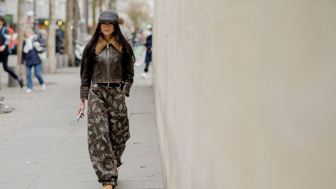 Street Style Queen Yoyo Cao trägt gleich mehrere Trendteile: Cargopants und Lederjacke.