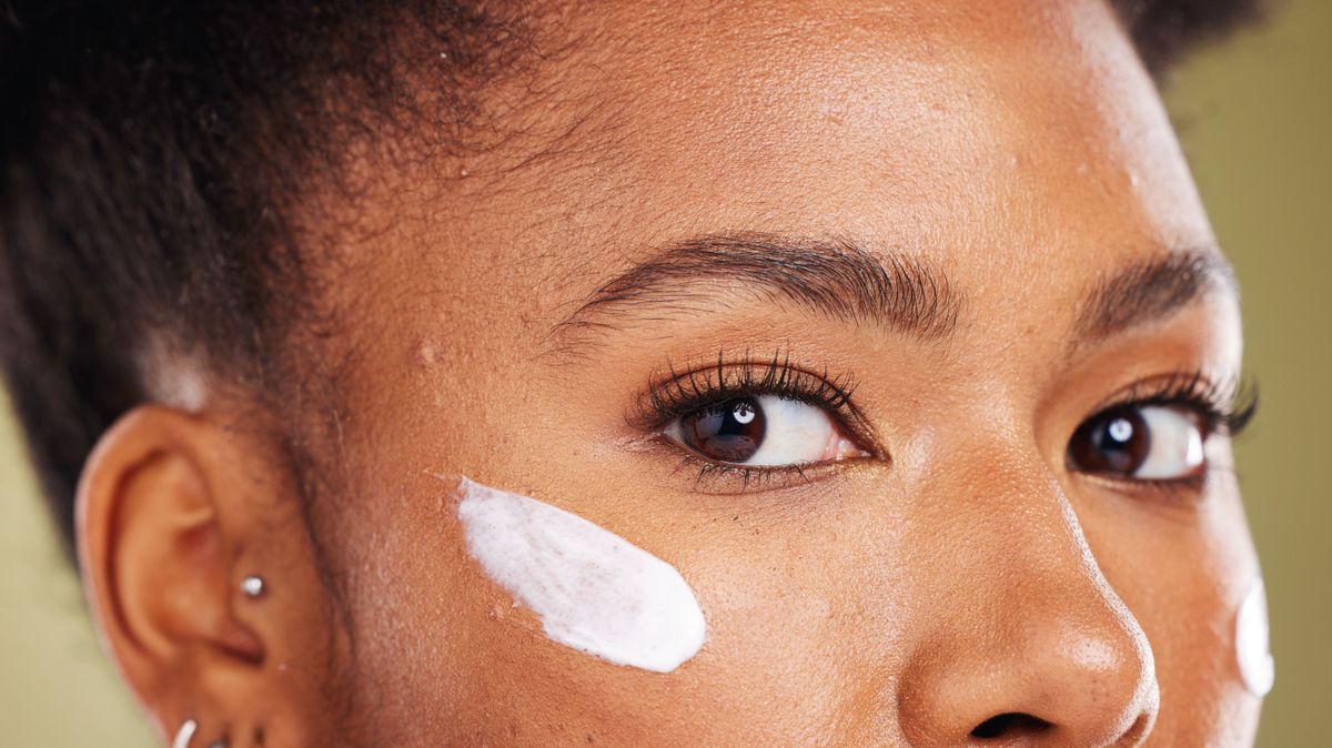 Black woman, eyes and cream for skincare cosmetics, makeup or lotion against a studio background. Closeup portrait of African American female face with moisturizer creme for facial cosmetic treatment