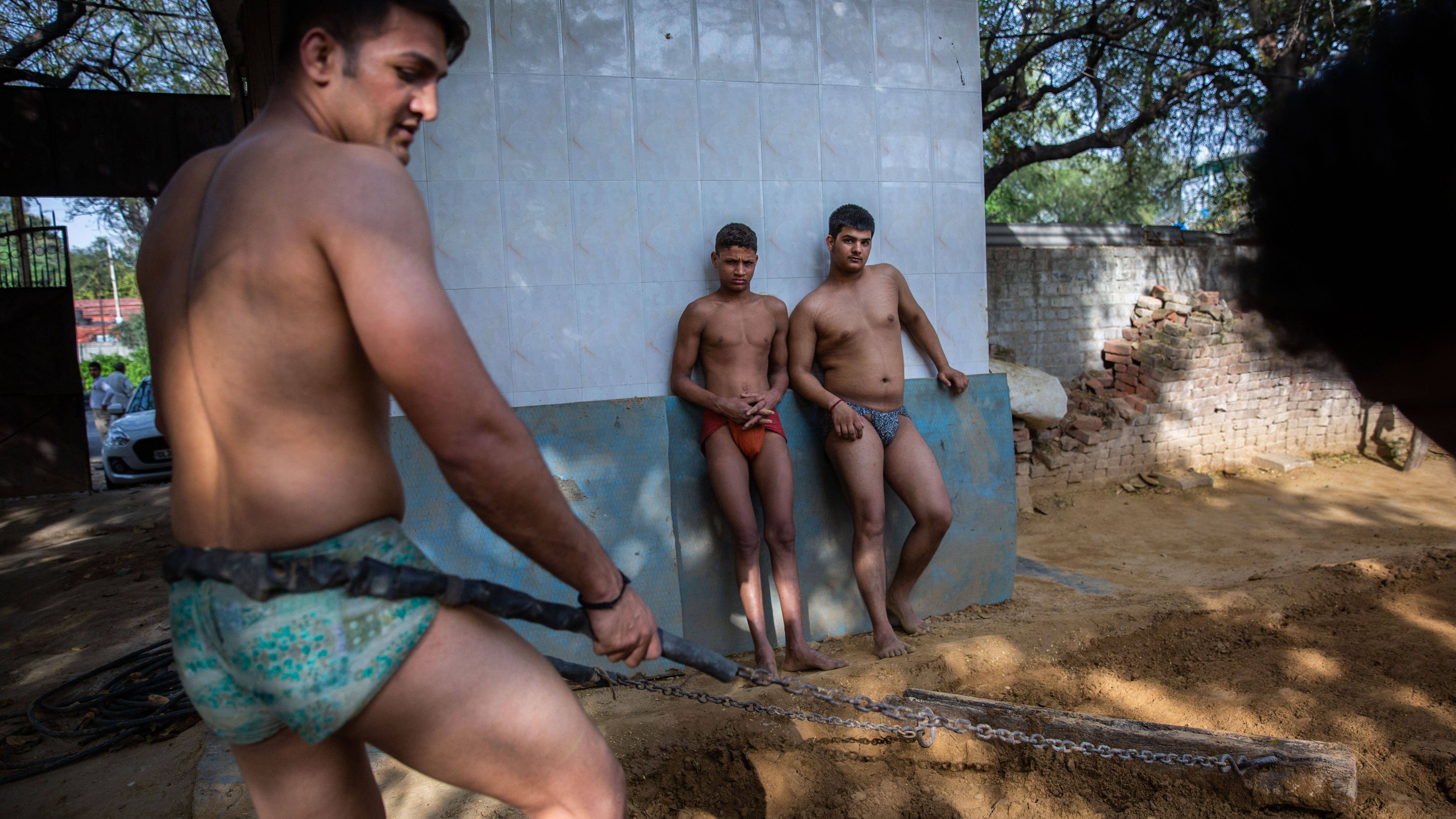 Der Kampfplatz heißt Akhada oder Akhara. Die Besonderheit ist der Sandboden. Hier ebnet ein Kushti-Ringer den Boden fürs Training.