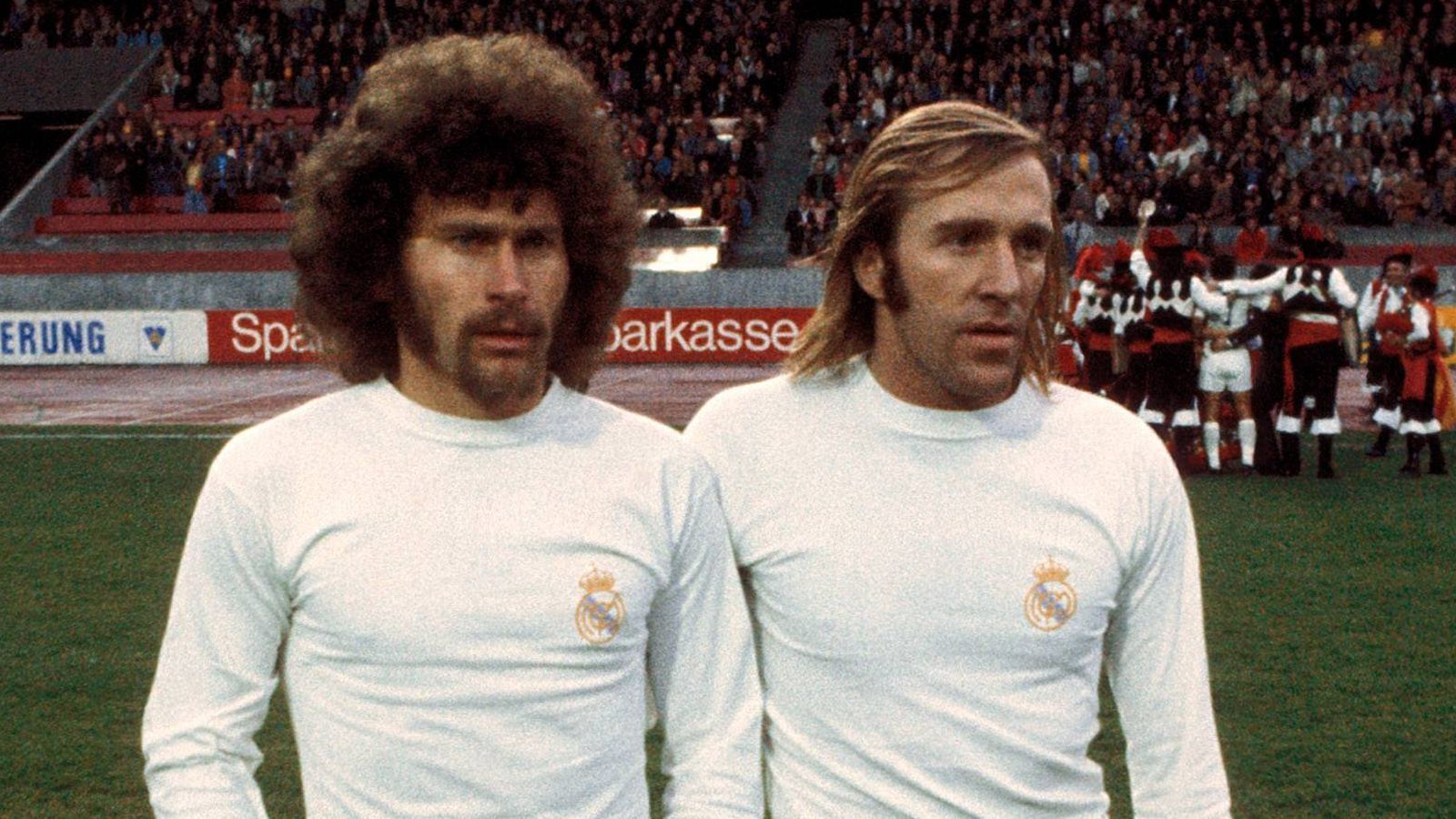 <strong>Netzer, Breitner und Stielike spielten für Real</strong><br>
                Der Tod des spanischen Diktators Franco 1975, der als Unterstützer Reals galt, verringerte ein wenig die politischen Spannungen zwischen den Klubs, die sportliche Rivalität bleibt aber bis heute brisant. In den 1970er und 80er Jahren nahmen auch einige deutsche Spieler wie Günter Netzer (r.), Paul Breitner (l.) und Uli Stielike für Real Madrid teil.