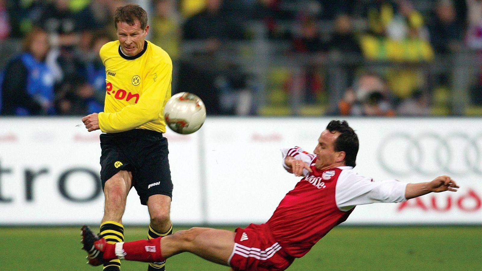 
                <strong>Stefan Reuter, Weltmeister 1990</strong><br>
                Bundesliga-Spiele/-Tore: 307/11 für Dortmund, 95/4 für die Bayern. Fast identisch zur Karriere von Jürgen, mit dem zehn Jahre zusammen in drei verschieden Klubs spielt, verläuft die von Stefan Reuter (im Bild li.). 1988 unterschreibt der ehemalige Nürnberger bei den Bayern, bleibt dort drei Jahre und wird 1989 und 1990 Meister. Zusammen mit Kohler wechselt der heutige Manager des FC Augsburg zu Juventus, um aber schon nach nur einer Spielzeit bei Borussia Dortmund durchzustarten. Mit dem BVB prägt er die Ära mit den Meisterschaften 1995, 1996 und 2002 sowie dem Champions League-Triumph 1997.
              