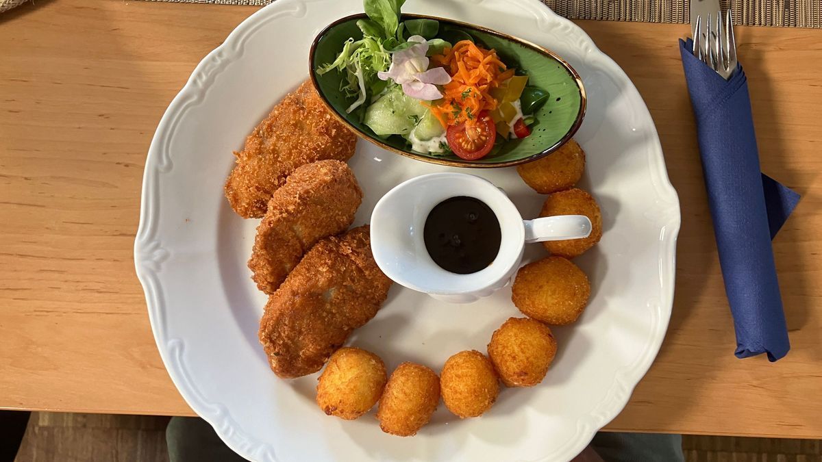 Schweinemedaillons im Parmesanmantel mit hausgemachten Kloßteigkroketten, Pfeffersoße und Salat  